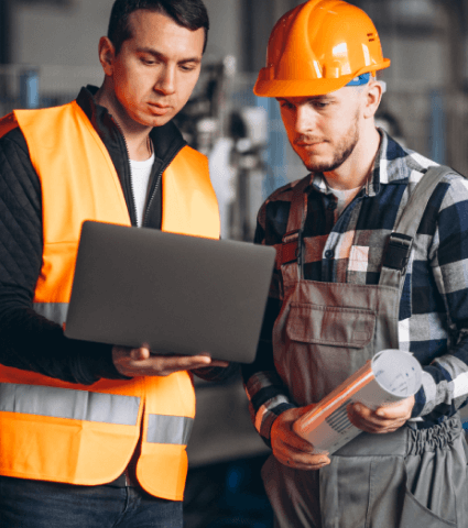 Два мужчины на производстве смотрят в ноутбук Два мужчины на производстве смотрят в ноутбук