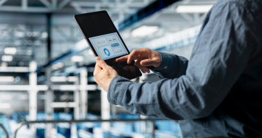 Мужчина держит планшет с графиками