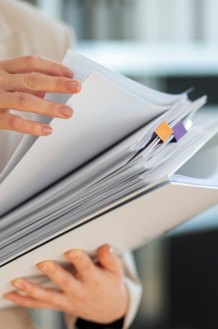 Женщина держит в руках стоку бумаг